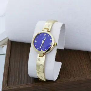 Primer plano de reloj de cuarzo para mujer con esfera azul, pulsera dorada y brillantes.