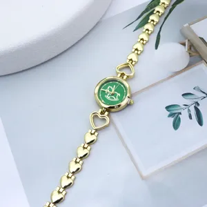 Elegante goldene Damen Quarzarmbanduhr mit schoenem Herzarmband und gruenem Schaukelpferdzifferblatt.