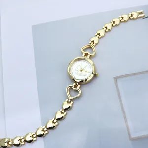 Modische goldfarbene Damen Quarz Armbanduhr mit Herz-Kettengliedern und Pony-Motiv.
