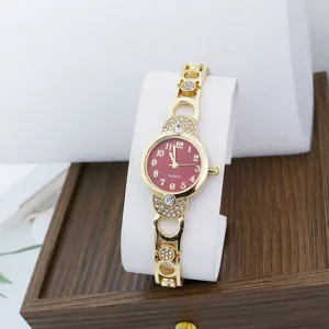 Close-up of women's quartz watch featuring a red dial, gold bracelet, and rhinestones.