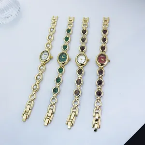 Detail view of stylish women quartz watches with gold link bracelets and colorful stone dials.