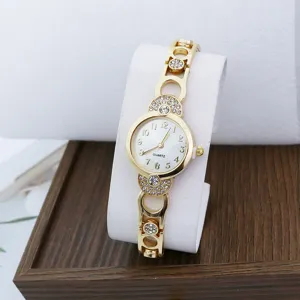Close-up detail of women's gold quartz watch featuring sparkling rhinestones and clear dial.