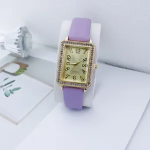 Elegante dames quartz horloge met paarse lederen band en gouden rechthoekige strass kast.