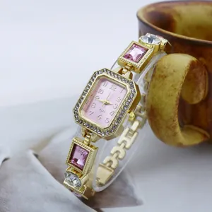 Goldene rechteckige Quarzdamenuhr mit rosafarbenem Zifferblatt, Strasslünette und buntem Armband.