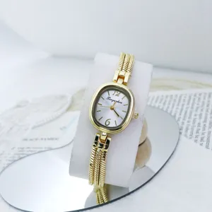 Elegante reloj de cuarzo dorado con delicada esfera ovalada y correa de múltiples hilos para mujer.