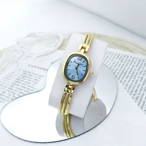 Vista detallada del elegante reloj de cuarzo con esfera ovalada pequeña y correa de cadena.