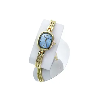 Reloj de cuarzo dorado para mujer con esfera ovalada azul y pulsera metálica fina y elegante.