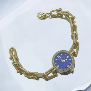 Goldene Damenquarzuhr mit elegantem Hufeisenkettenarmband und funkelnden Strasssteinen.