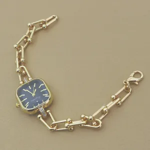 Modische Damenarmbanduhr mit quadratischem Zifferblatt und goldenem Gliederarmband, Detail.