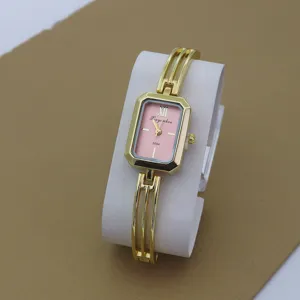 Close-up detail of an elegant gold quartz watch featuring a pink dial and unique bangle strap.