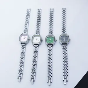 Petite montre quartz femme cadran carre avec bracelet en metal argente au design elegant.