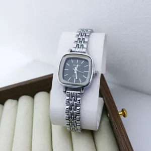 Élégante petite montre quartz femme à cadran carré avec un bracelet en métal élégant.
