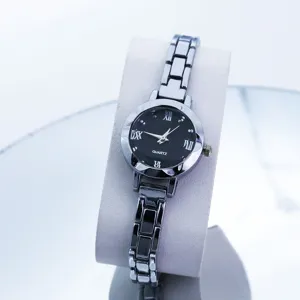 Orologio da donna al quarzo dettaglio quadrante con fondo nero e cinturino metallico.