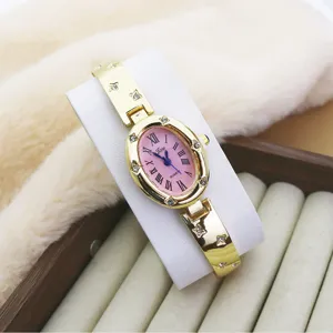 Elegant women's oval pink dial quartz watch with stylish rhinestone gold bracelet strap.