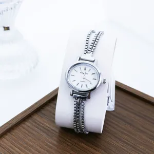 Detailansicht einer minimalistischen silbernen Quarzuhr mit zartem Mehrstrangkettenarmband.