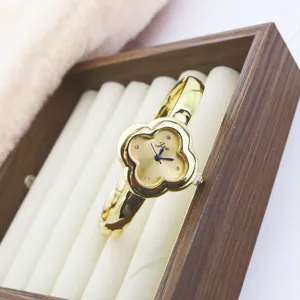 Luxury gold clover design quartz watch for women, elegant bangle bracelet timepiece style.