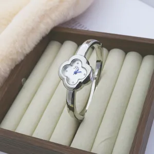 Silver clover bangle quartz watch for women, elegant diamond-inlaid wristwatch chic.
