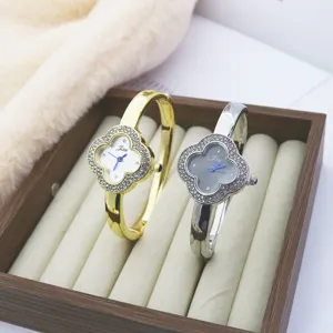Luxury clover rhinestone bracelet quartz watch for women, elegant gold and silver fashion timepiece.