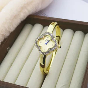 Detailed view of the gold-tone clover quartz watch featuring sparkling rhinestone embellishments.