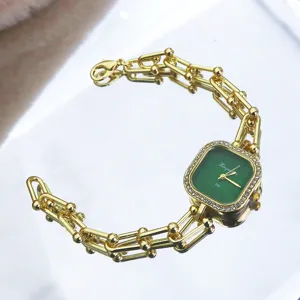 Green square dial quartz watch with gold tone chain bracelet and rhinestone bezel detail.