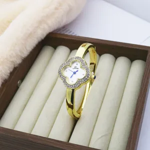 Elegant clover quartz wristwatch featuring dazzling rhinestone bezel and gold finish bracelet design.
