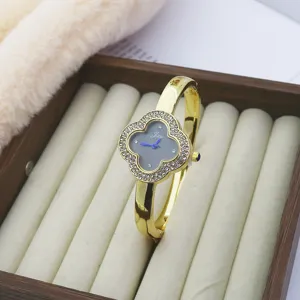 Luxury clover rhinestone quartz watch for women, elegant gold bracelet wristwatch detail.