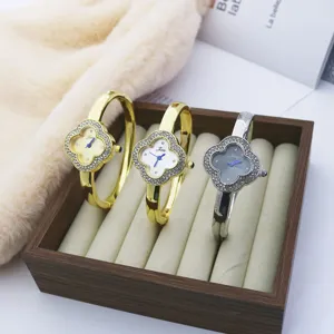 Luxury rhinestone clover bangle watch for women, stylish quartz wristwatch with elegant design.