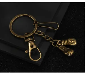 Detailed close up view of vintage bronze metal boxing glove keychain pendant and clasp.