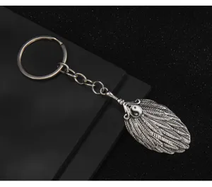 Detail view of vintage Chinese style yin yang bagua feather fan metal keychain pendant.