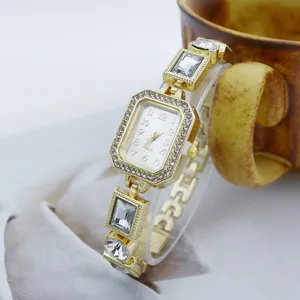 Detailansicht einer eleganten goldenen Quarzuhr mit funkelnden Strasssteinen und Kristallgliedern.