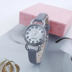 Damen Quarzarmbanduhr mit grauem Lederarmband, edler Strasslünette und klaren Ziffern.