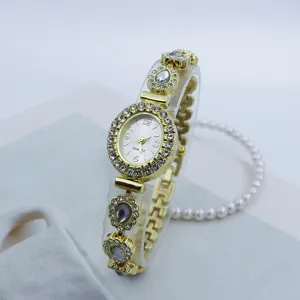 Detailaufnahme einer feinen goldenen Damen-Quarzuhr mit ovalem Strass-Zifferblatt und Kristall.