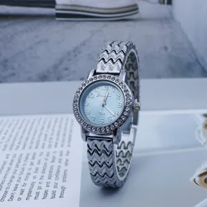 Detailed shot of a stylish women's quartz watch featuring a rhinestone bezel and silver wavy strap.