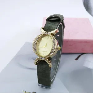 Reloj de cuarzo para mujer con pedrería, esfera ovalada dorada y correa de nailon verde.