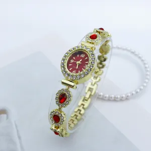 Exquisites Quarzuhren-Detail mit rotem ovalem Zifferblatt, funkelnden Strasssteinen und Armband.