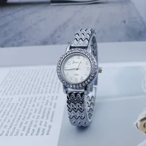 Silver rhinestone women quartz watch with wavy metal bracelet and clear dial numbers.