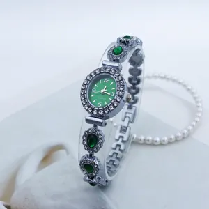 Nahaufnahme der eleganten ovalen Quarz-Armbanduhr in Grün mit funkelnder Strass-Lünette.