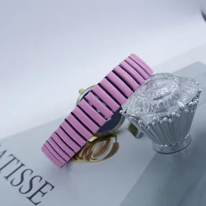 Close-up of pink stretch band quartz watch with crystal decor prop, elegant vintage design.