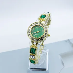 Women's gold tone quartz watch with green dial, rhinestone bezel and gem bracelet.