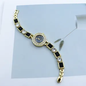 Close-up detail of luxury gold quartz watch dial with sparkling rhinestone crystal strap links.
