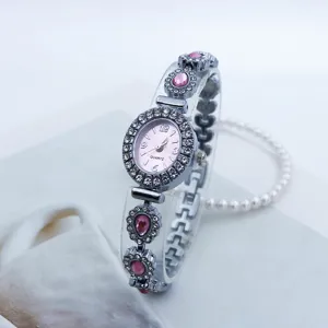 Elegante Damen Quarzuhr mit Strass Lünette und rosafarbenem Zifferblatt Armband.