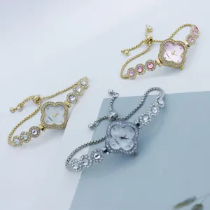 Dettaglio orologio trifoglio con quadrante in strass brillante e cinturino regolabile.