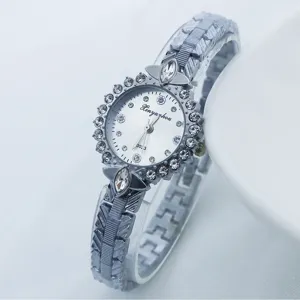 Gros plan détaillé d'une montre quartz femme argentée élégante avec lunette en strass brillants.