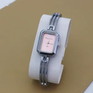 Detailed closeup of elegant women quartz watch featuring pink square dial and silver bangle strap.