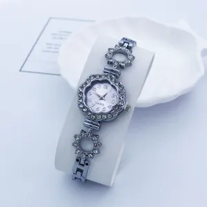 Vista dettagliata di un elegante orologio al quarzo con strass da donna e quadrante floreale.