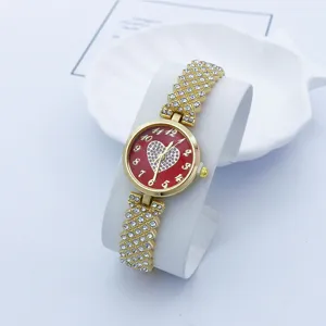 Strass Quarzarmbanduhr Detail, gold Metallarmband mit rotem Herz Zifferblatt, elegante Damenuhr.