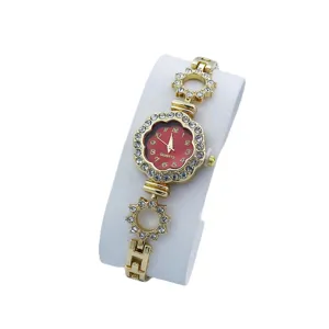 Elegante orologio da polso al quarzo da donna dorato con quadrante rosso e strass luminosi.