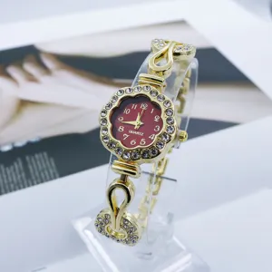 Vista de cerca de los detalles del reloj de cuarzo con flor de estrás, bisel brillante.