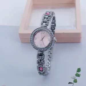 Detailansicht einer luxuriösen Damen Quarz Strass Uhr mit rosafarbenem Zifferblatt und Armband.