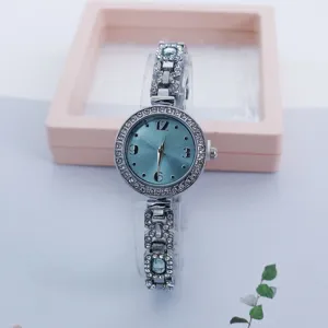 Nahaufnahme einer stilvollen Damen Strass Quarzuhr mit hellblauem Zifferblatt und Armband.